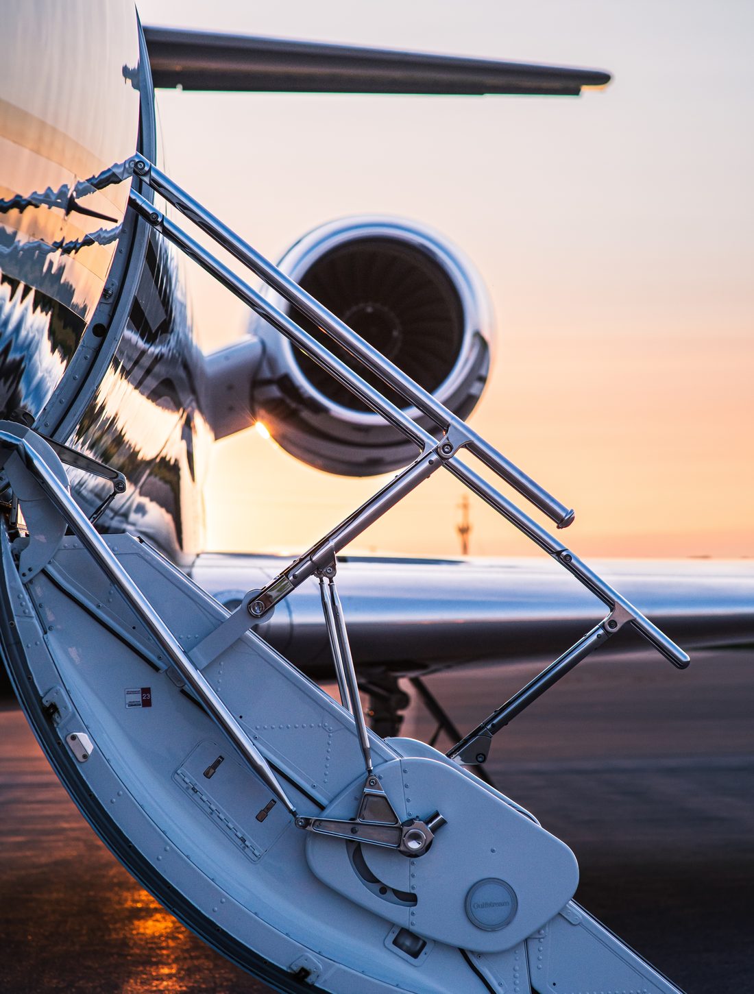 An open airstair on a private jet at sunrise